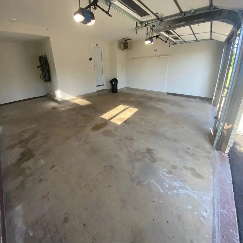 Two-car garage with an old floor coating worn away in patches across the slab