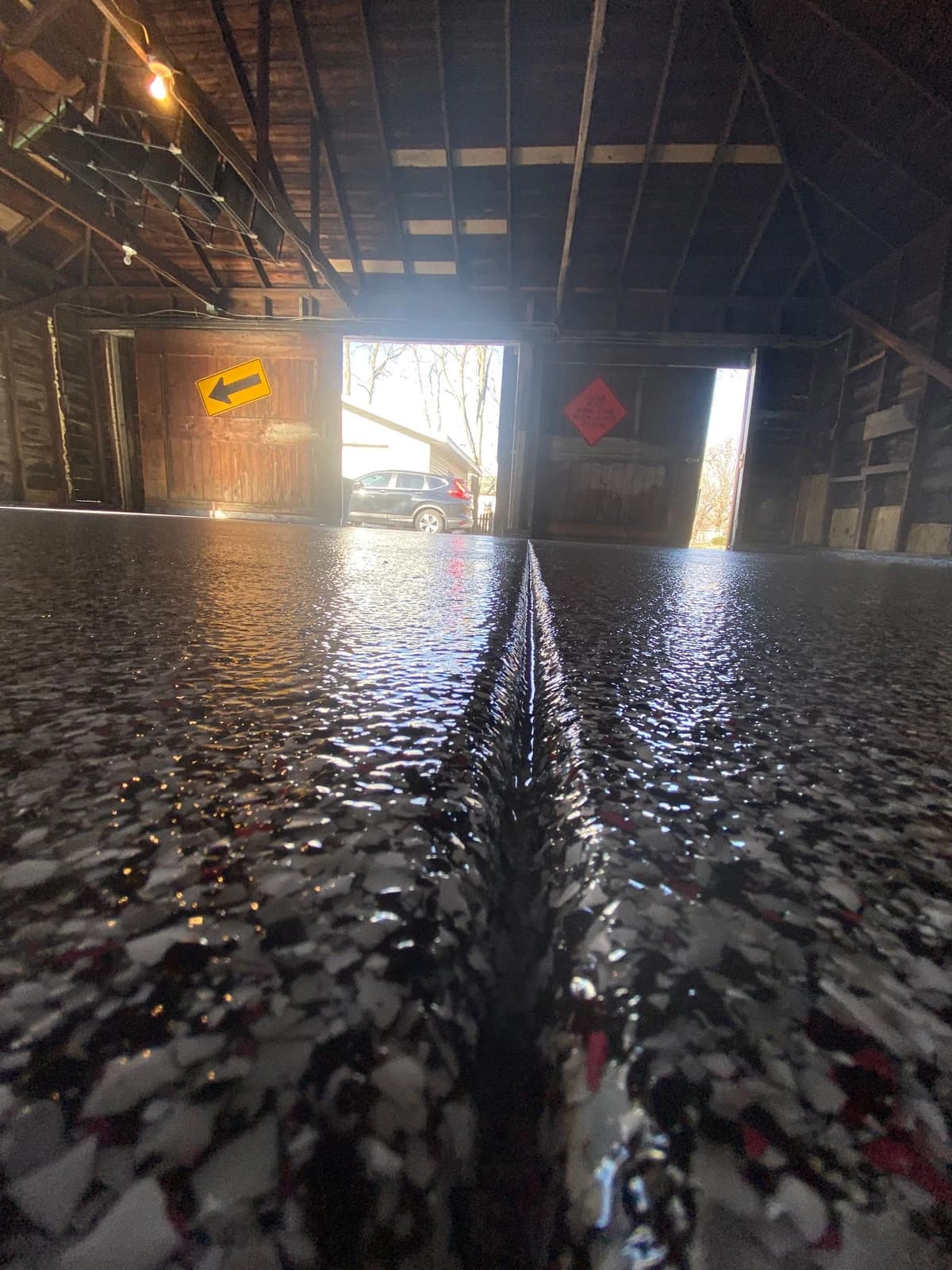 Barn breezeway with a dark flake concrete coating running to the doors