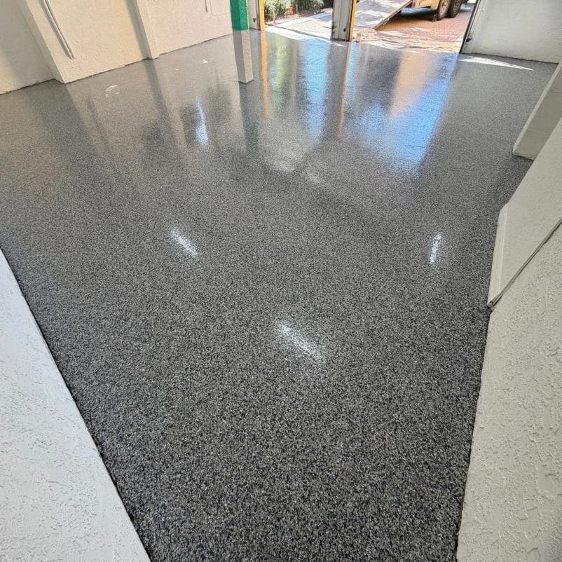 Covered carport with a gray flake concrete coating between support columns