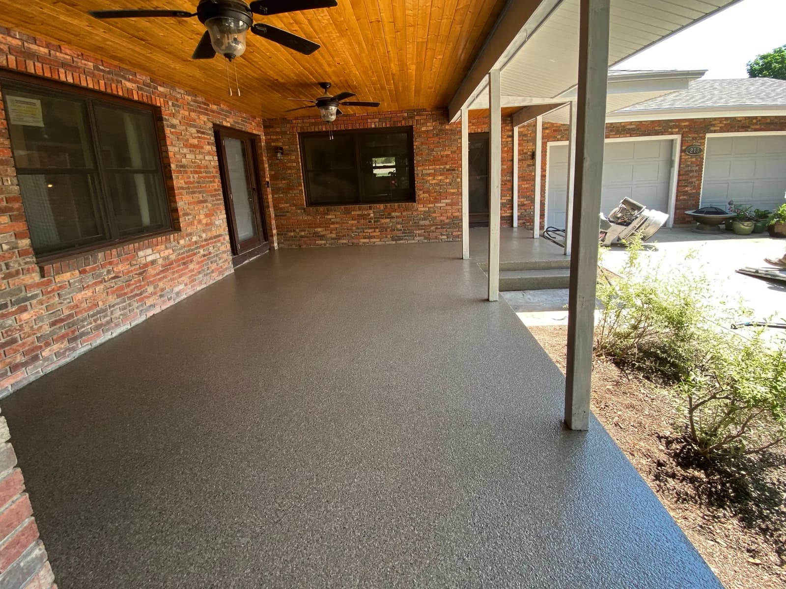 Covered brick patio finished with a gray flake concrete coating
