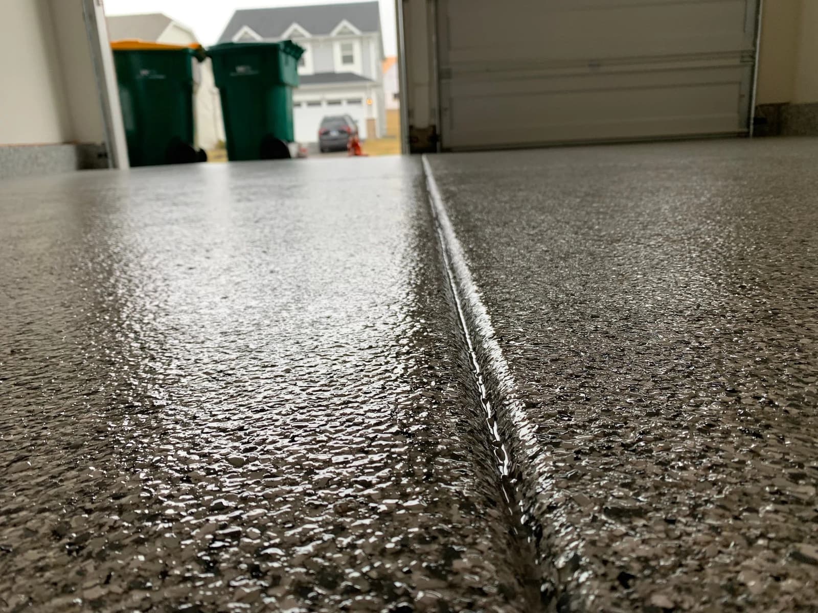 Driveway and garage threshold with a textured flake concrete coating
