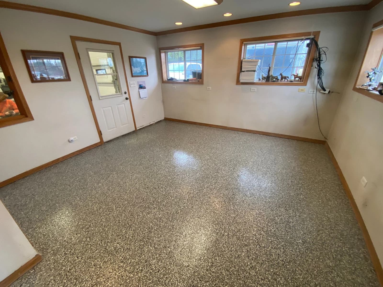Finished interior room with trim and a gray flake floor coating