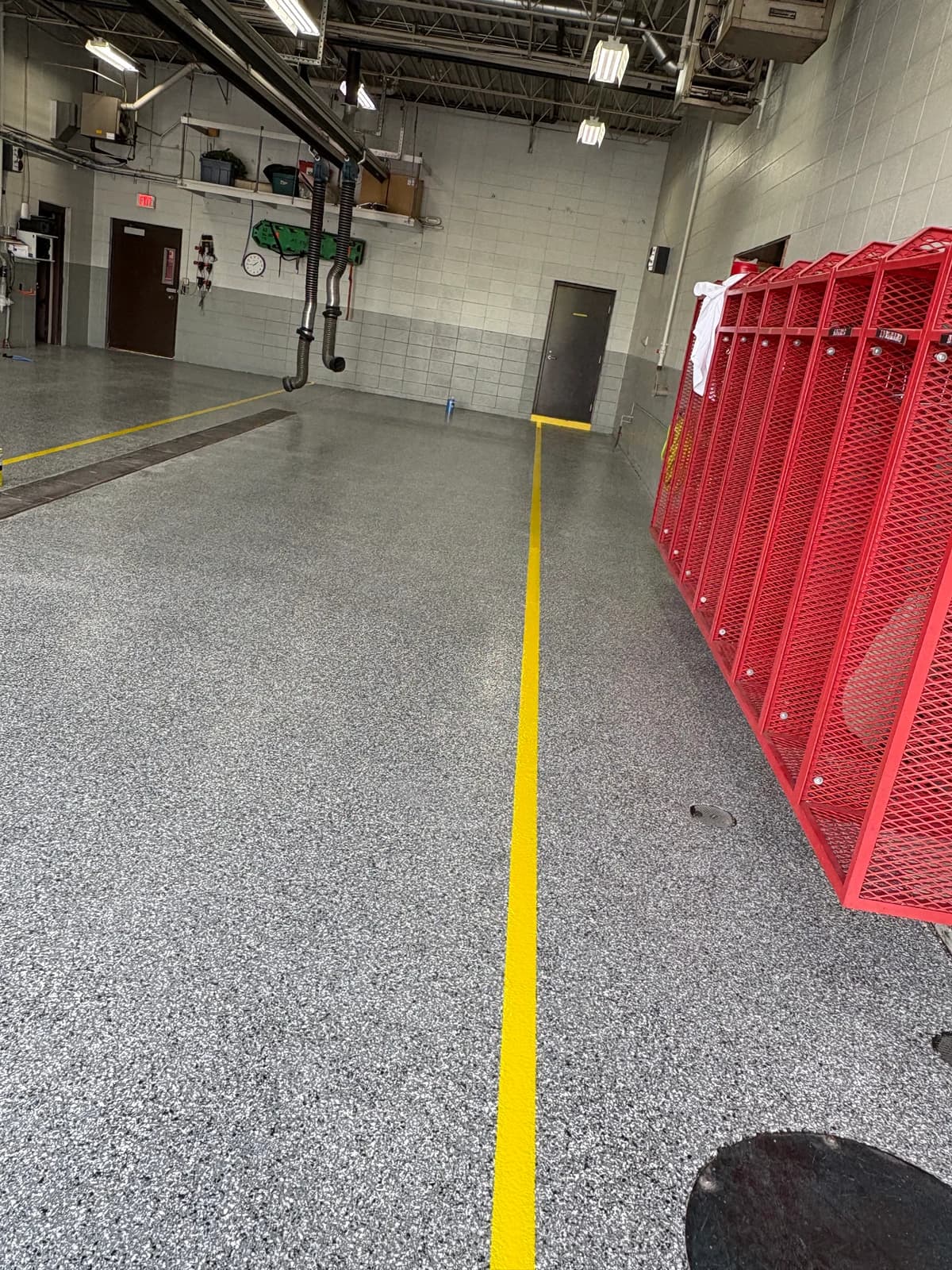 Fire station bay with a gray flake floor coating and yellow safety striping