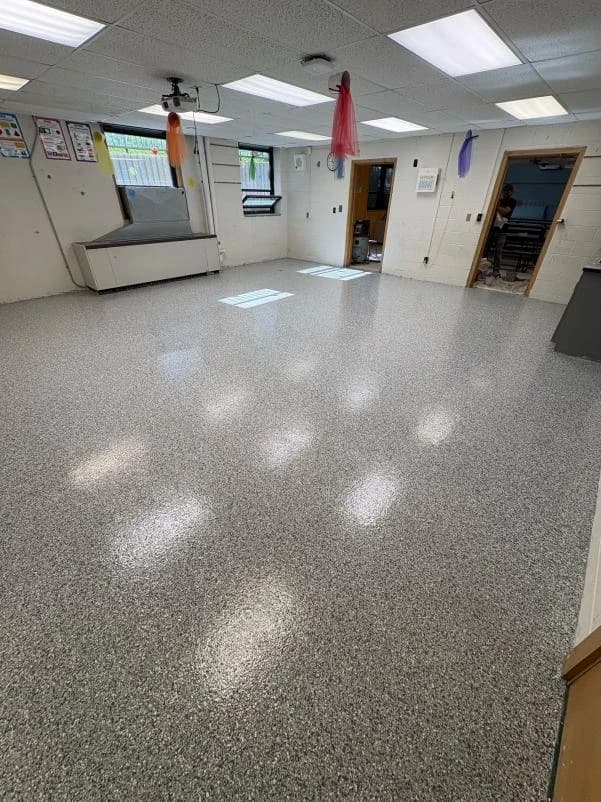 Institutional room with a seamless gray flake floor coating