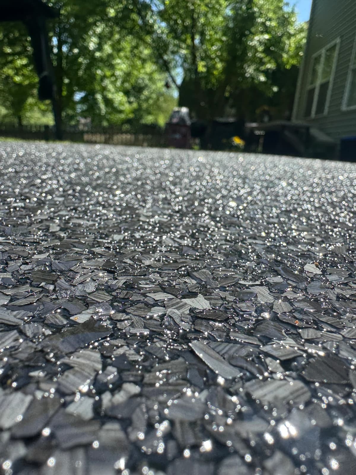 Close-up of a dark decorative flake coating on an outdoor concrete surface