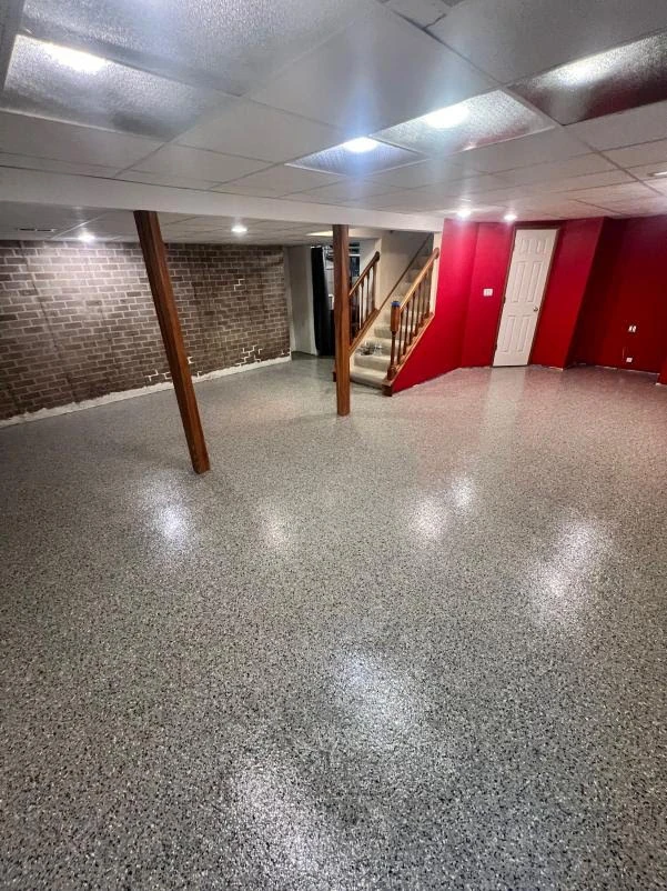 Finished basement with a speckled gray flake floor coating running wall to wall